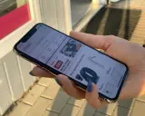 Dłoń trzyma iPhone 11, na ekranie aplikacja Allegro. Idealne iphone 11 wymiary do przeglądania ofert.