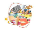 Kreative Hände falten Papier und malen bunte Kreise. Kinder und Erwachsene basteln gemeinsam.