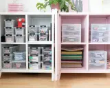 Ein aufgeräumter Bastelschrank mit vielen beschrifteten Boxen, die FIMO, Marker und Bastelmaterialien enthalten. Alles ist perfekt organisiert.