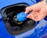 Dłoń zdejmuje niebieską nakrętkę z wlewu AdBlue, zapobiegając krystalizacji płynu w dieslu.