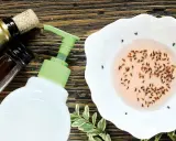 Hausmittel gegen Fruchtfliegen: Eine Schale mit gefangenen Fliegen, daneben eine Seifenflasche und Wein.