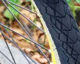 Błyszczące szprychy i bieżnik opony rowerowej, sugerujące najlepsze opony szosowe na jesienną przejażdżkę.