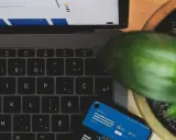 Laptop, telefon i roślina tworzą scenę dla kampanii brandowej.