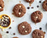 Gros plan sur des cookies au chocolat parsemés de morceaux de chocolat blanc et noir. Un petit bol jaune contient des morceaux de chocolat, comme un cookie stick.
