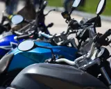 Manillar de moto con espejos y parte del depósito. Un carnet de moto a punto de ser usado.