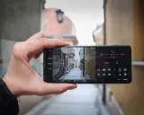 Dłoń trzyma smartfon Sony Xperia Pro i, kadrując wąską uliczkę. Widoczne ustawienia aparatu.