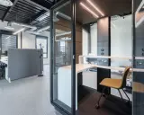 Un bureau moderne avec des cabines acoustiques et du mobilier flex office, idéal pour la concentration.