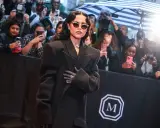 Jenna Ortega deslumbró en la Met Gala con un elegante abrigo negro y gafas de sol.