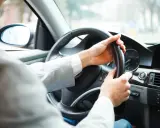 Mężczyzna za kierownicą zastanawia się, czy autocasco warto. Bezpieczeństwo na drodze to podstawa.