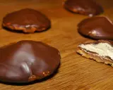 Chokladbiskvier recept: Läckra chokladöverdragna biskvier med krämig fyllning på en träyta.
