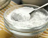 Sypki cukier puder w szklanej miseczce, gotowy do użycia. Dowiedz się, jak zrobić cukier puder w domu!
