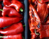 Dos recipientes llenos de pimientos rojos. A la izquierda, pimientos frescos y brillantes. A la derecha, pimientos asados, con la piel arrugada y un tono más oscuro.