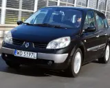 Czarny Renault Scenic 2 1.6 16v jedzie autostradą. Kierowca w okularach przeciwsłonecznych prowadzi auto.