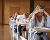 En tjej med händerna mot pannan känner efter studenten ångest under ett prov.