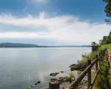 Ciclista ammira un lago in Lombardia, godendosi una delle tante ciclabili panoramiche.