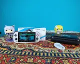 Biały handheld Trimui Smart Pro z grami, figurki Funko Pop i etui na konsolę.