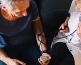 Pielęgniarka mierzy ciśnienie starszemu mężczyźnie. Wynik to 80/50.