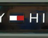 Litery TOMMY HILFIGER na tle z efektem marmuru. Poznaj, jak rozpoznać podróbkę Tommy Hilfiger, zwracając uwagę na detale logo.