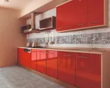 Cocina moderna con gabinetes rojos brillantes y una cenefa de azulejos con patrones geométricos en blanco y negro.