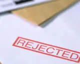 Czerwony stempel "REJECTED" na dokumencie, który mógł być wnioskiem o pozwolenie na broń.