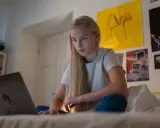 Dziewczyna szuka w internecie informacji, gdzie można pracować w wieku 16 lat.