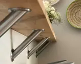 Stabile Metallwinkel befestigen die Holztheke auf der Arbeitsplatte. Ein Blumenstrauß ziert die Oberfläche.