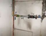 Instalacja wodna z widocznym elementem pokazującym, jak działa reduktor ciśnienia wody, z manometrem i zaworem.