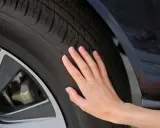 Una mano toca la banda de rodadura de un neumático, sugiriendo la pregunta de cuánto duran las ruedas de un coche.