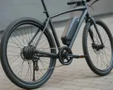 Vélo électrique noir, moteur dans la roue arrière, batterie sur le cadre. Prêt à débrider pour plus de puissance.