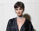 Frau mit einer modernen Frisur zwischen Pixie und Bob, trägt ein schwarzes Seidenkleid und einen funkelnden Choker.
