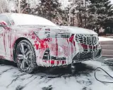 Czerwony samochód pokryty pianą, gotowy do mycia. Czy można myć auto w mrozie? To pytanie zadaje sobie wielu kierowców zimą.
