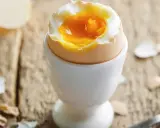 Jajko na miękko w kieliszku, z płynnym żółtkiem. Czy jajka podwyższają cholesterol? Pytanie, które nurtuje wielu.