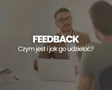 Dwóch mężczyzn przy biurku, jeden z nich udziela feedbacku. Czym jest feedback i jak go udzielać?
