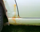 Rdza na progu samochodu i pęcherze pod lakierem. Aby zapobiec korozji, należy regularnie konserwować auto.