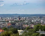 Widok na Kraków z punktu widokowego. W oddali widać kościół Mariacki i Wawel, a bliżej zabudowania miejskie i zieleń.