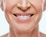 Sonrisa de mujer con piel madura, mostrando cómo disimular el surco nasogeniano con técnicas de maquillaje y cuidado facial.