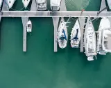 Vue aérienne d'un port avec plusieurs voiliers amarrés. Le coût de l'assurance bateau dépend de nombreux facteurs.