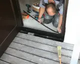 Montaż drzwi zewnętrznych próg. Fachowiec dopasowuje element progu, by zapewnić szczelność i estetykę wejścia.