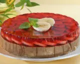 Kolorowe ciasto bananowe z galaretką na biszkopcie, ozdobione plasterkami banana i miętą.