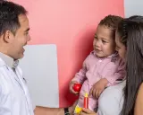 Médico habla con madre y niño, buscando entender los problemas de concentración del pequeño.