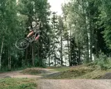Mountainbike-åkare flyger genom luften i en skogspark nära Stockholm.