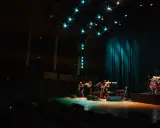 En jazzgrupp spelar på en scen under Stockholm Jazz Festival. Ljusen lyser upp scenen och publiken sitter i mörkret.