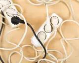 Chaotische Kabel und Steckdosen auf Holz. Hier sind einige kabel verstecken ideen, um Ordnung zu schaffen.