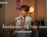 Christina Stielli, som lärt sig att hon är bra nog, ler och vilar hakan i handen. Hon sitter i en fåtölj och texten "Återhämta dig från stress" syns.