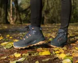 Jesienne buty trekkingowe na tle liści. Idealne, by dowiedzieć się, jak się ubrać w góry jesienią.