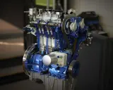 Przekrój silnika 1.0 Ecoboost w kolorze niebieskim, z widocznymi tłokami i paskiem rozrządu.
