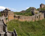 Die Chinesische Mauer, eine beeindruckende yajuj majuj location, schlängelt sich über grüne Hügel.