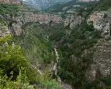 Impresionante cañón con paredes rocosas y vegetación exuberante, ideal para rutas senderismo La Rioja.