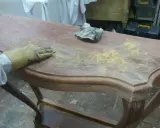 Proceso de como decapar un mueble antiguo, lijando la superficie para eliminar la pintura vieja.