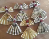 Selbstgemachter Christbaumschmuck: Kleine Weihnachtsengel aus Notenpapier und Perlen, die zum Basteln einladen.